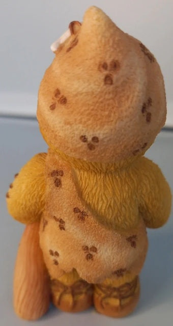 Yellow teddy bear with brown spots on a light gray background