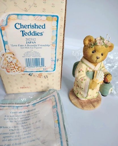 Cherished Teddies Japan 'Love Fans A Beautiful Friendship' girl with fan figurine shown next to its original packaging box and certificate of authenticity.