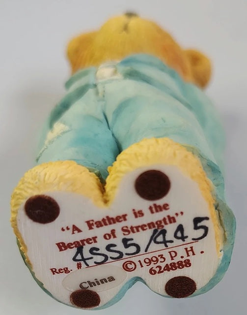 Back view of a teddy bear containing text and a serial number.