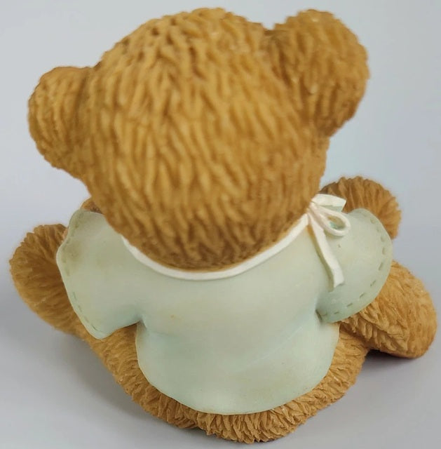 Brown teddy bear with a green shirt on a white background