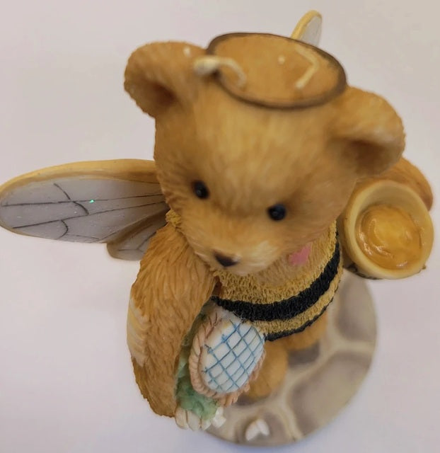 Teddy bear with bee wings and a honeycomb on a white background