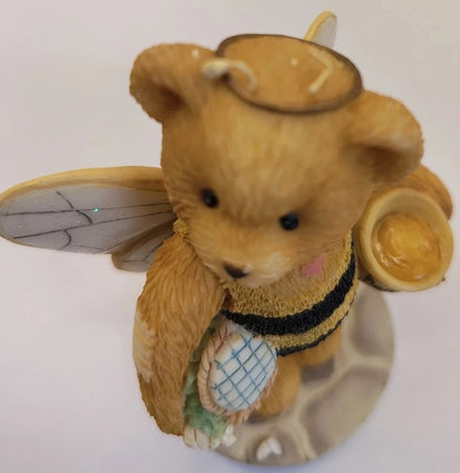 Teddy bear with bee wings and a honeycomb on a white background