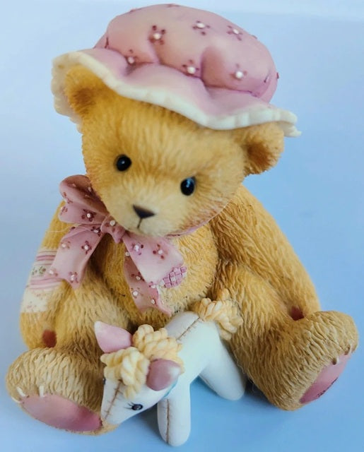 Teddy bear with a pink hat and scarf on a light blue background