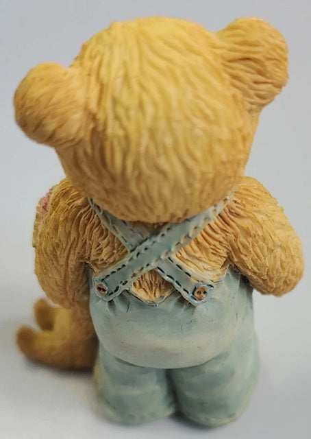 Teddy bear wearing overalls on a white background