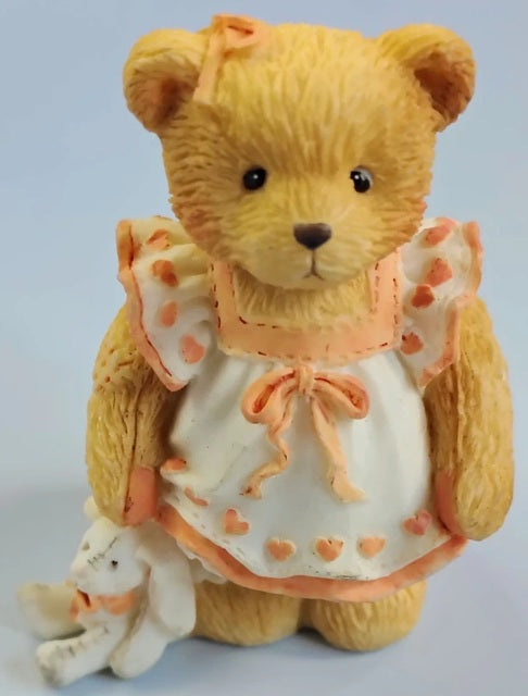 Cherished Teddies Child Of Kindness teddy bear wearing a white dress with pink accents on a light blue background. Our Cherished Family Younger Daughter. 624853.