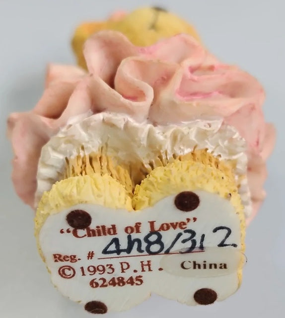 Decorative item with 'Child of Love' label and floral design on a gray background