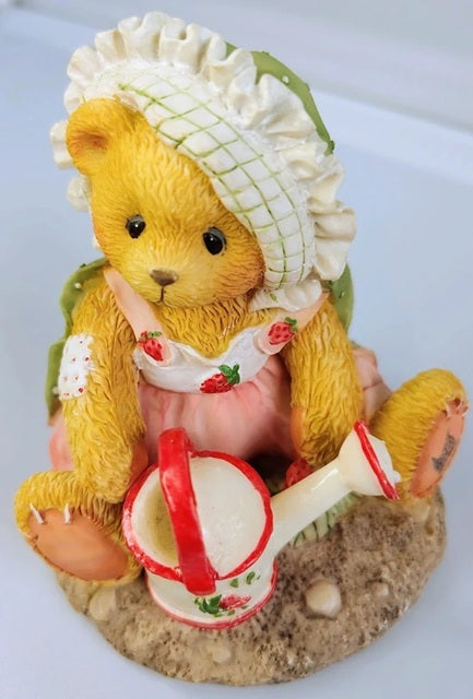 Decorative bear figurine with a bonnet and strawberry-themed outfit on a white background