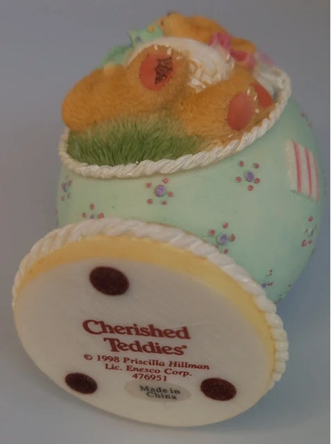 Decorative figurine of a teddy bear in an egg, with 'Cherished Teddies' branding.
