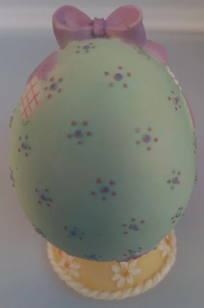 Pastel-colored Easter egg with a bow on a white background