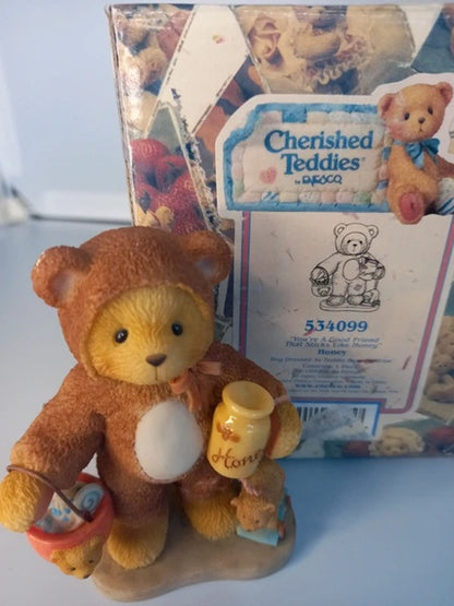 Teddy bear with a honey jar in front of a Cherished Teddies box