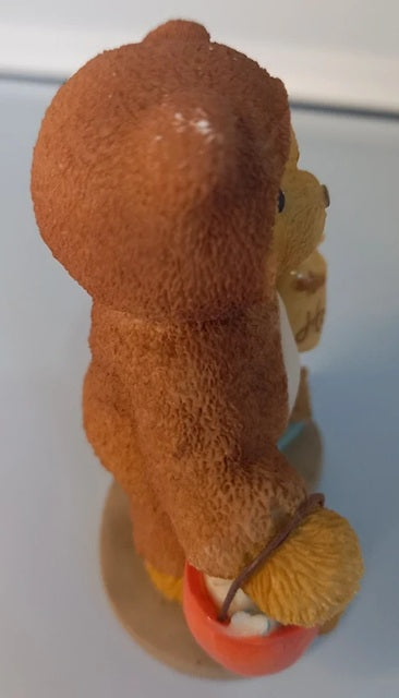 Brown teddy bear with a carrot on a white background