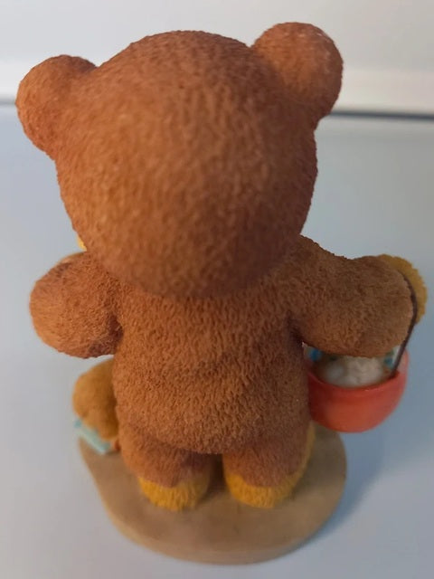Brown teddy bear holding a basket on a white background