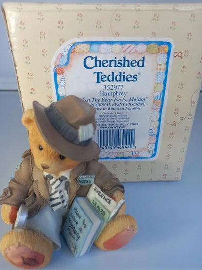 Cherished Teddies figurine with a cowboy hat and trench coat in front of its packaging.