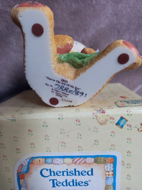 Cherished Teddies toy on a box with a purple background