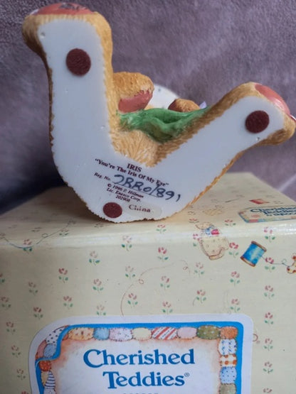 Cherished Teddies toy on a box with a purple background
