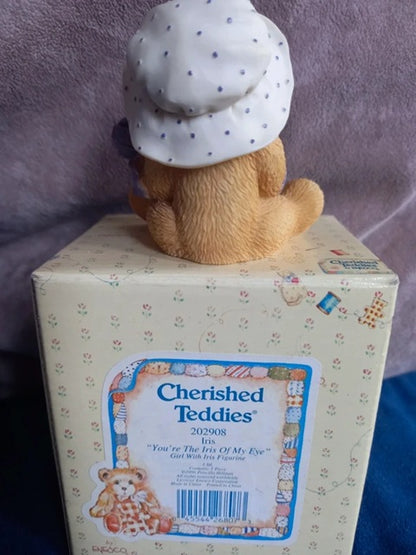 Cherished Teddies figurine on top of a box with a purple background
