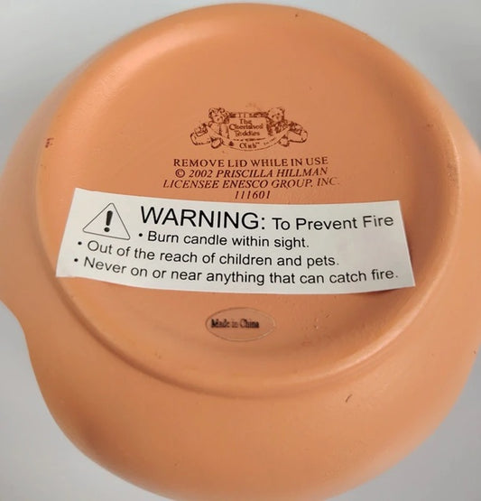 Terracotta-colored container with a warning label on a gray background