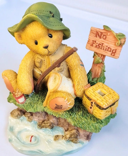 Bear figurine dressed as a fisherman with a 'No Fishing' sign and fishing rod.