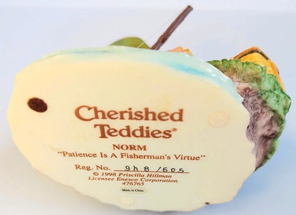Cherished Teddies teddy bear with a white face and green body on a light blue background
