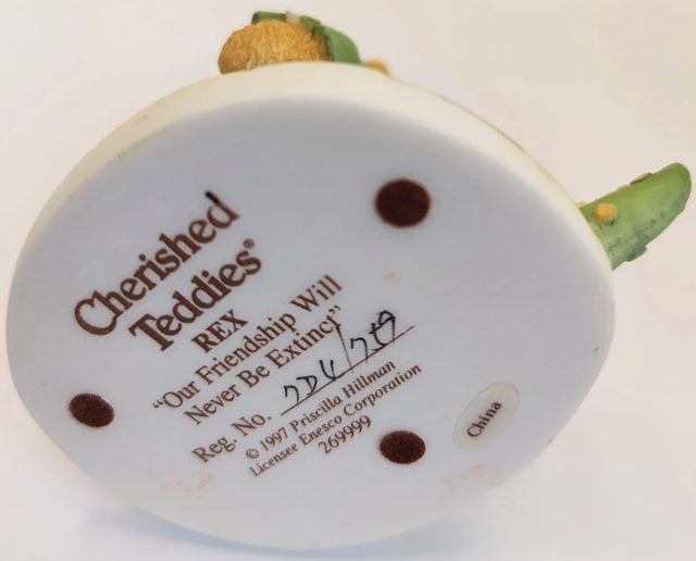 Back view of a 'Cherished Teddies' bear with branding and product details.