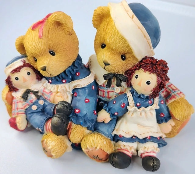 Two teddy bears and two dolls in vintage clothing on a white background