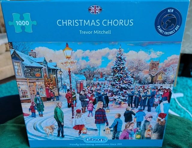 Jigsaw puzzle box titled 'Christmas Chorus' by Trevor Mitchell with a snowy village scene on the cover.