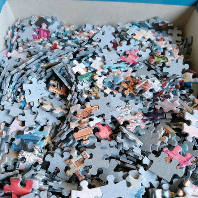 Box of assorted puzzle pieces with a mix of colors
