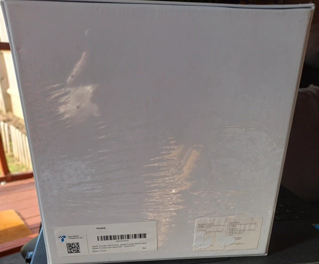 White product box with labels and a QR code on a blurred background