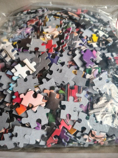 A clear plastic bag filled with many jigsaw puzzle pieces in assorted colors and shapes, photographed close up.