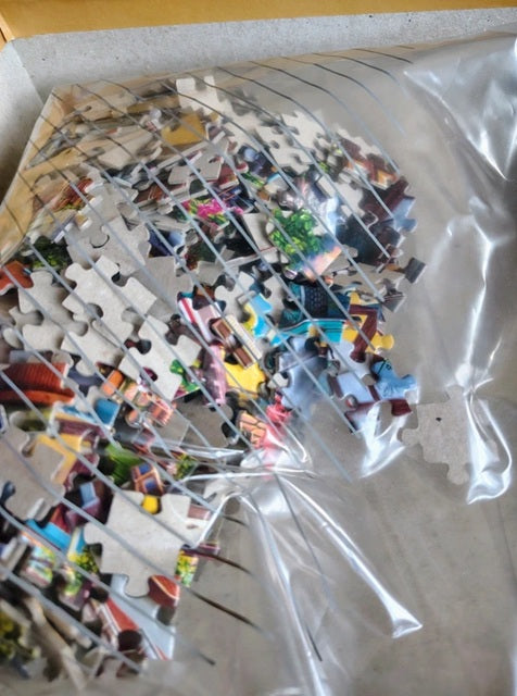 Pile of puzzle pieces with colorful images on a white surface