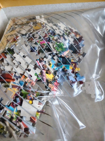 Pile of puzzle pieces with colorful images on a white surface