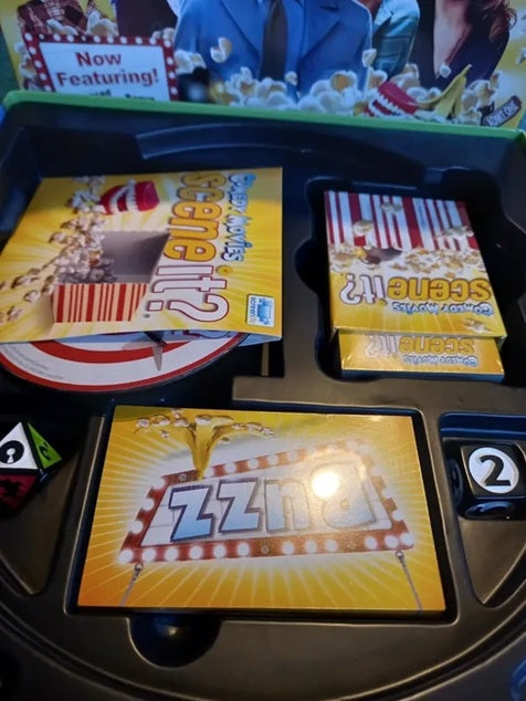 Board game components including cards and a spinner with movie-themed graphics.