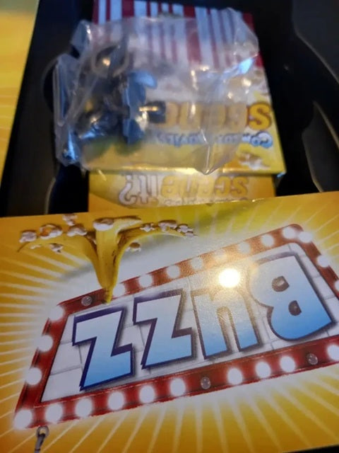 Zzzs candy package with a close-up of a blue lollipop in the background.