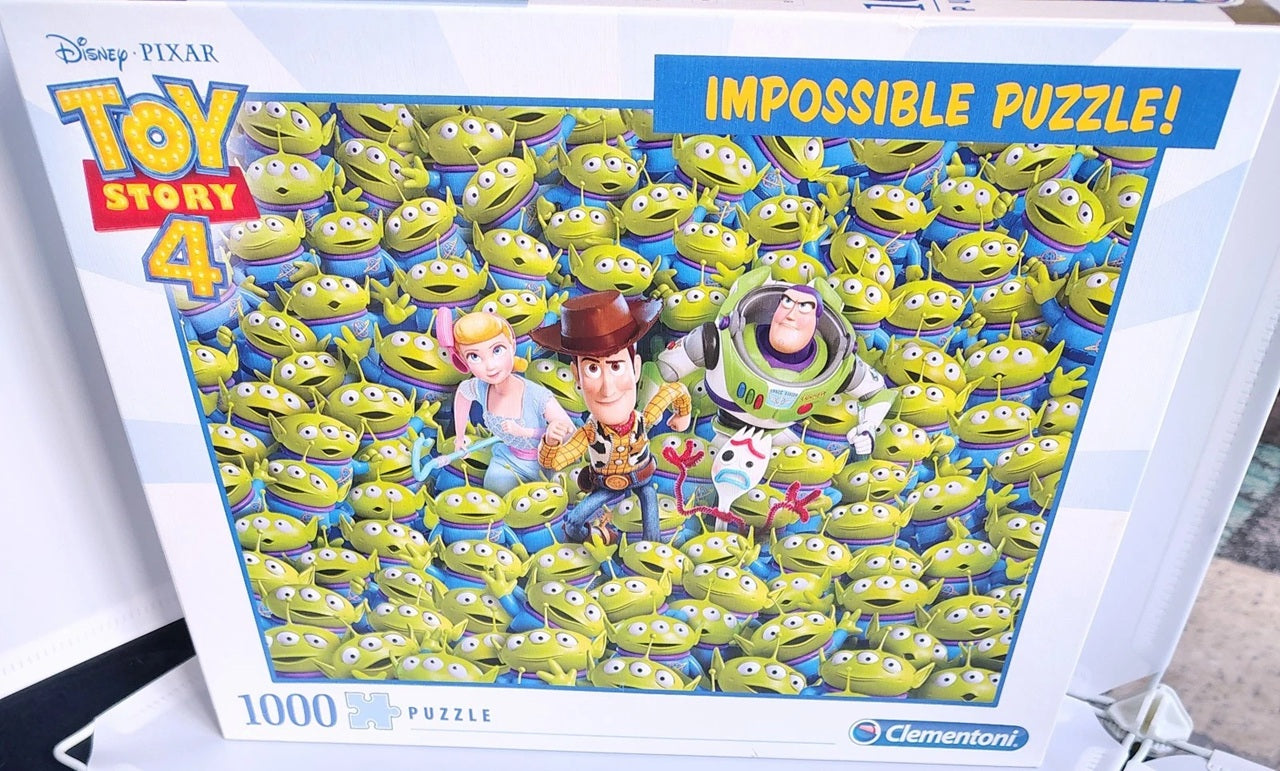 A boxed 1000-piece jigsaw puzzle from Disney Pixar Toy Story 4, featuring a dense collage of green Alien characters with Woody, Buzz Lightyear, and Jessie on the front. The Clementoni brand logo is visible in the bottom right corner.