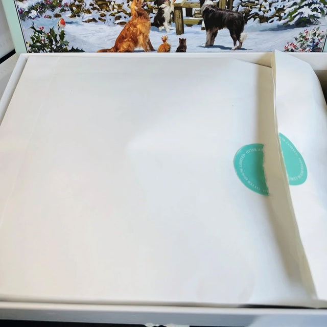 White product with green label on a snowy scene with dogs in the background