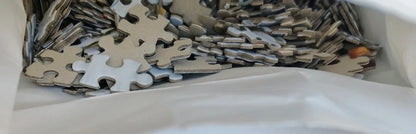Pile of puzzle pieces with a focus on metallic and white colors.