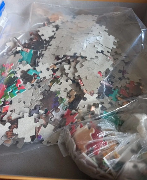 Jigsaw puzzle pieces in a clear plastic bag on a table
