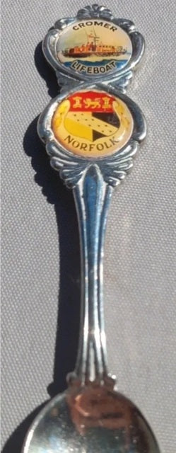 Spoon with embedded labels from different companies on a gray background
