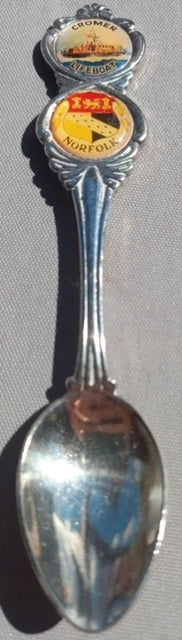 Silver spoon with vintage labels on a gray background
