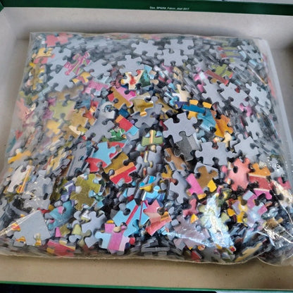 Pile of assorted puzzle pieces in a clear plastic bag on a cardboard surface