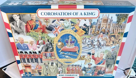 Jigsaw puzzle box titled 'Coronation of a King' with images of people and royal symbols on a blue, red, and white background.