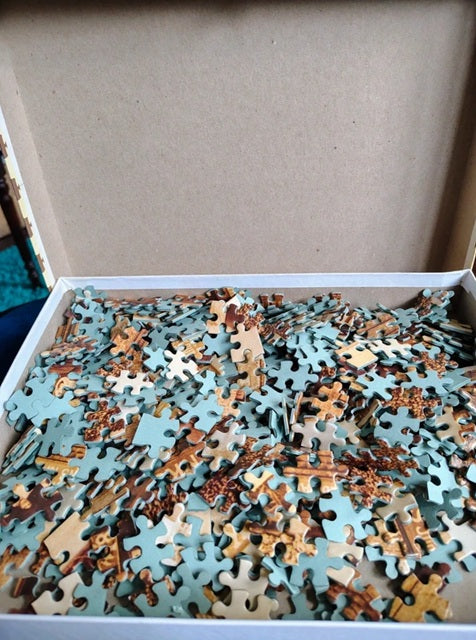 Box of assorted puzzle pieces on a light blue background