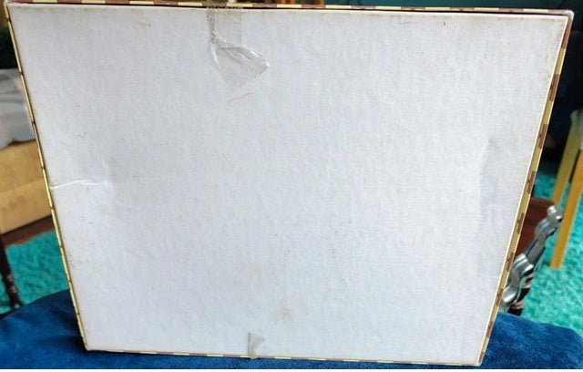 White marble slab with gold frame on a blue surface