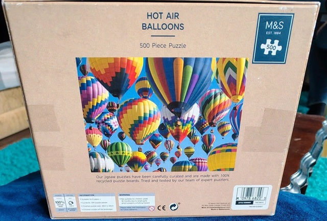 Box of a 500-piece puzzle featuring hot air balloons with M&S branding.