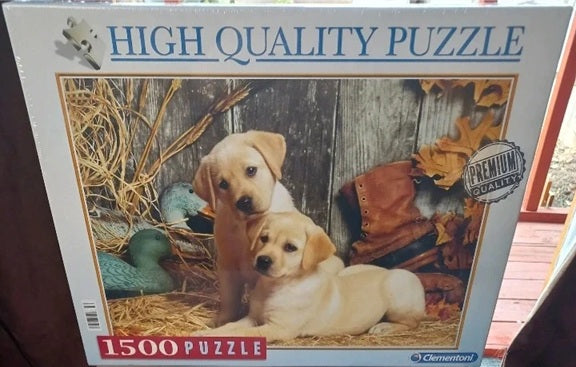 Jigsaw puzzle box with two puppies and a duck on a wooden background