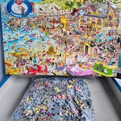 Puzzle with a partially completed scene of a beachside town, showing people and activities.