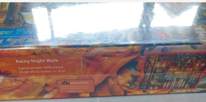 Jigsaw puzzle box titled 'Rainy Night Walk' with colorful design on a reflective surface.
