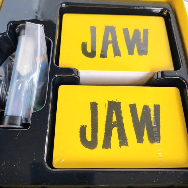Yellow game cards with 'JAW' text in a black tray
