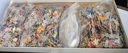 Box of assorted colorful puzzle pieces in clear bags