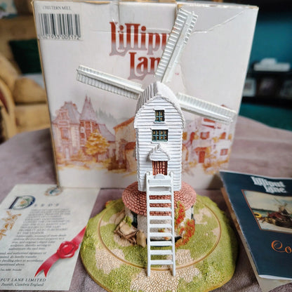 Miniature windmill model on a decorative base with 'Lilliput Lane' packaging in the background.